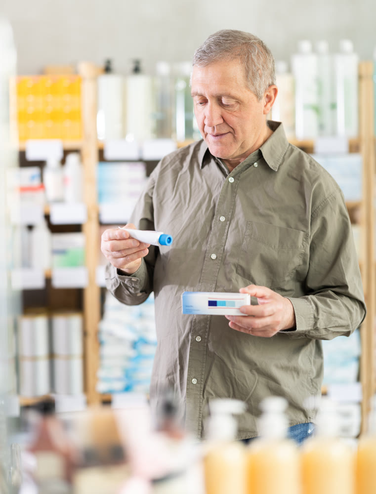 Senior man buys ointment at pharmacy