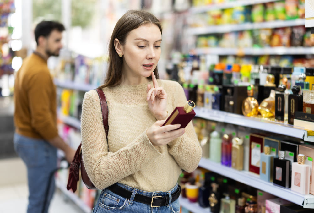 Woman spends time in store, looking for goods and select perfume