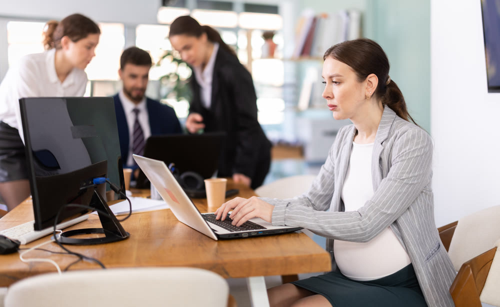 Pregnant woman working on laptop in office