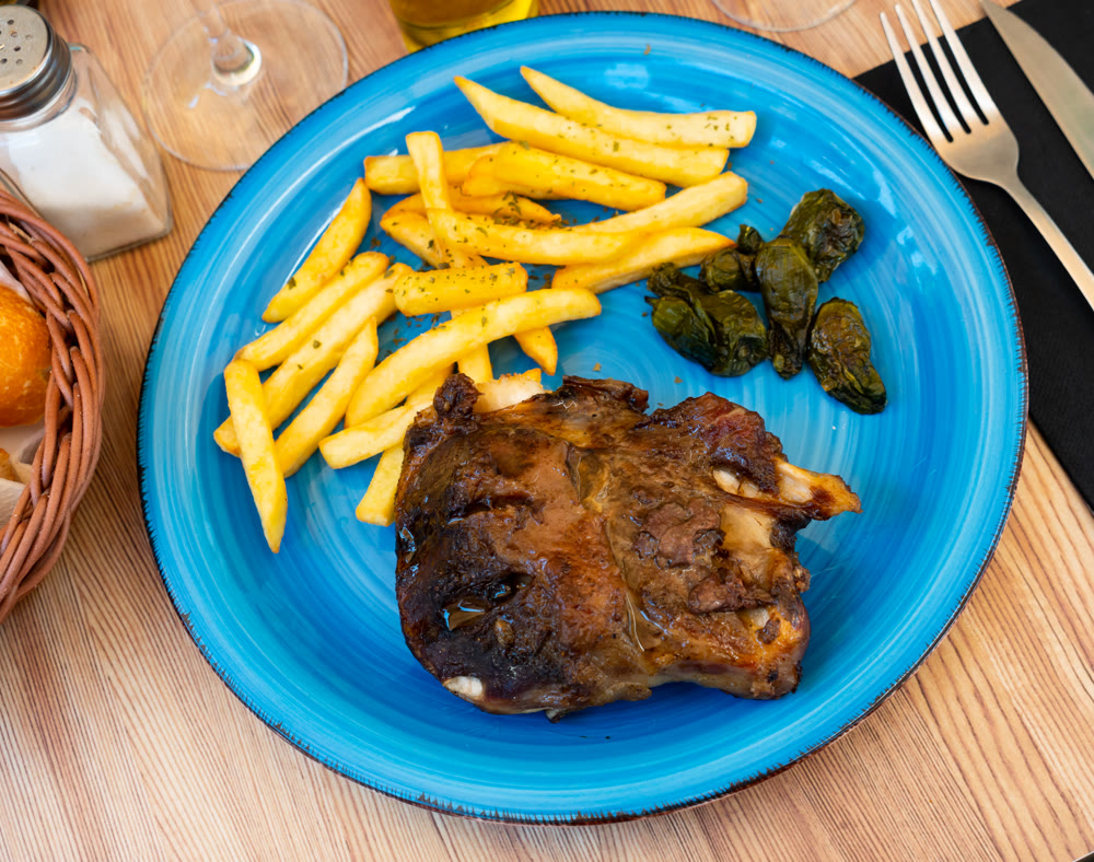 Baked pork knuckle and peppers with French fries