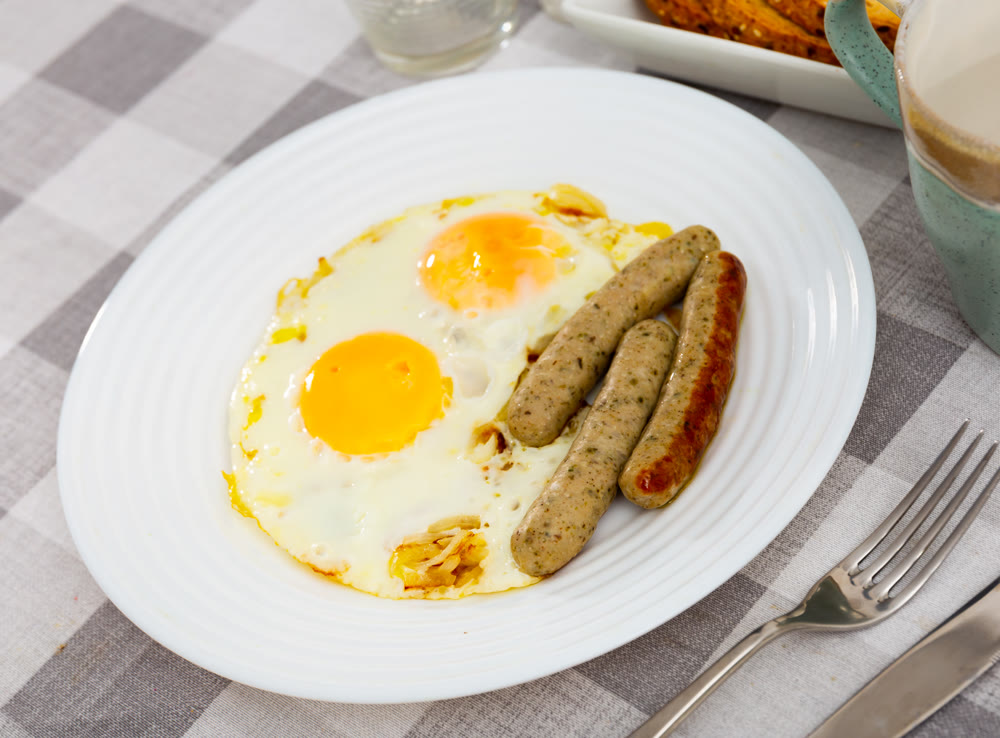 Fried eggs with onions served with sausage
