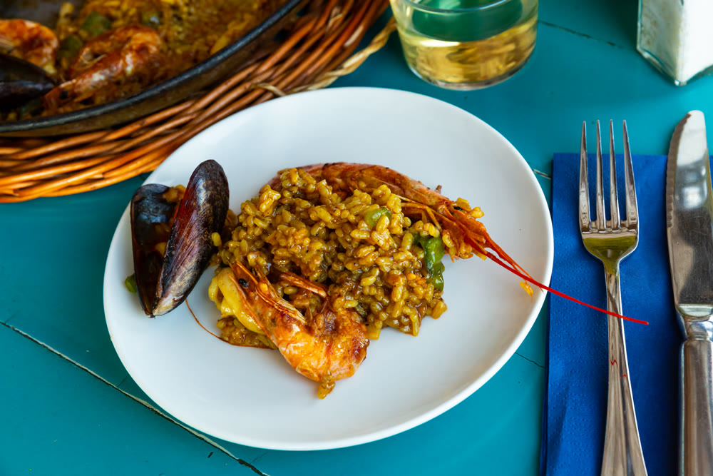 Delicious traditional Valencian seafood paella - savory rice dish with shrimps and clams