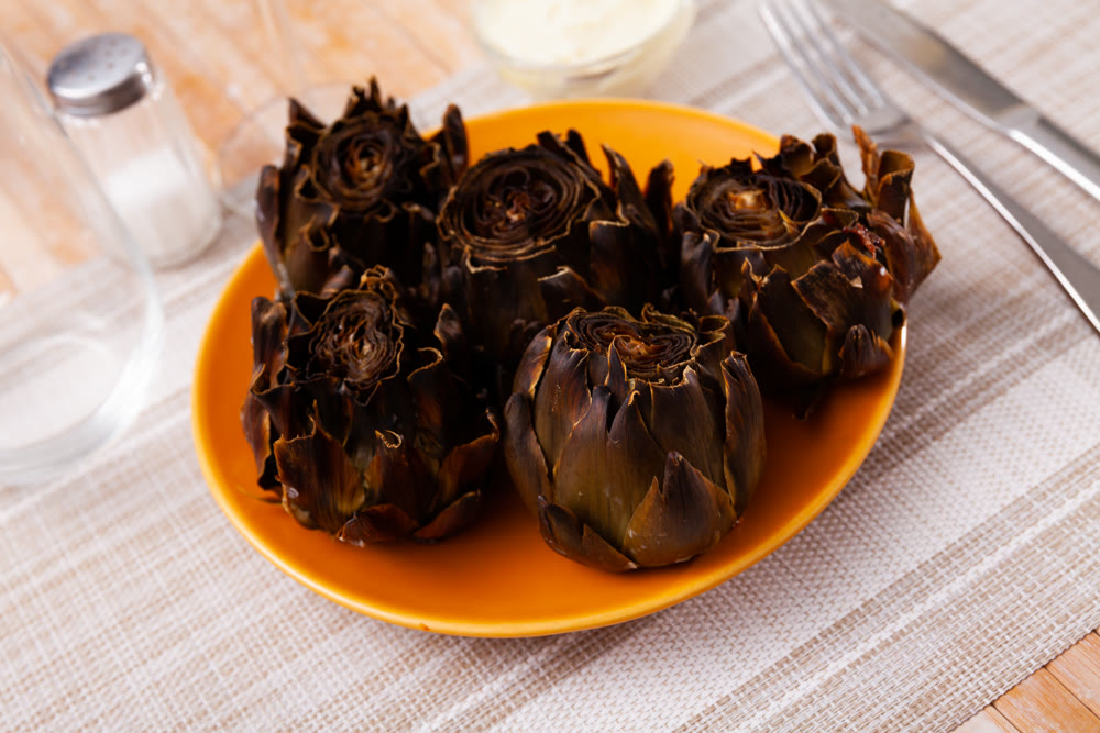 Portion of baked artichokes served on table