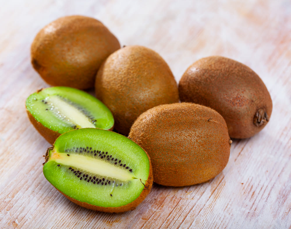 Whole and halved kiwi fruits