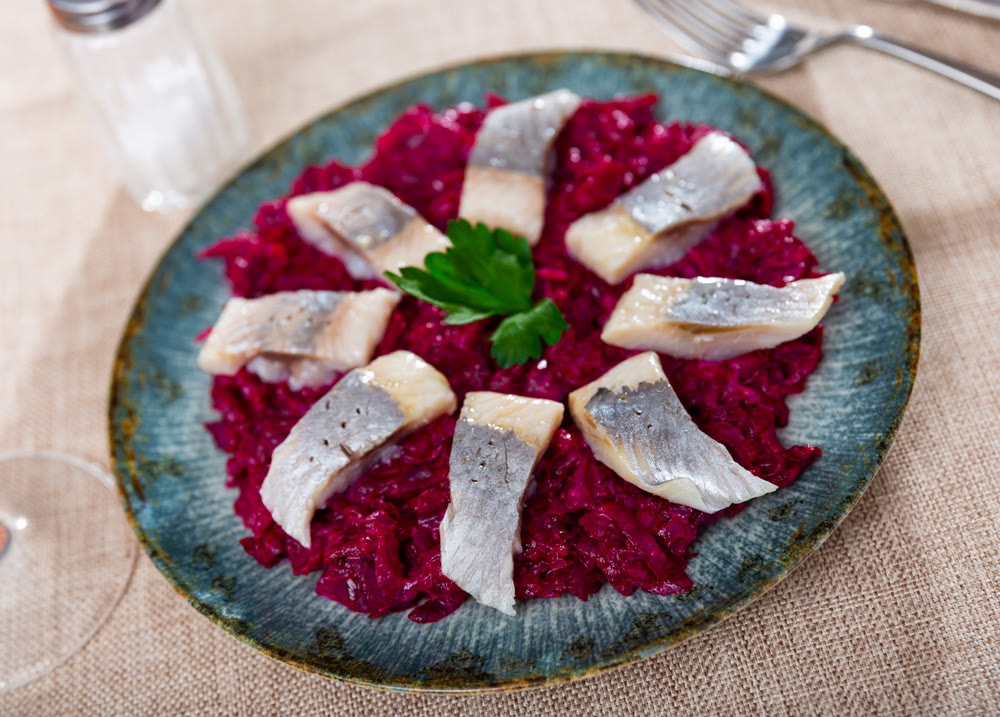 On pillow of beetroot salad - pieces of lightly salted herring are arranged in circle