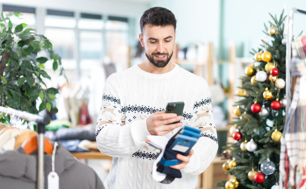 Man scans QR code and label of socks, X mas shopping