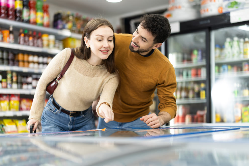 Couple spends time in store, looking for necessary goods and get out from refrigerator