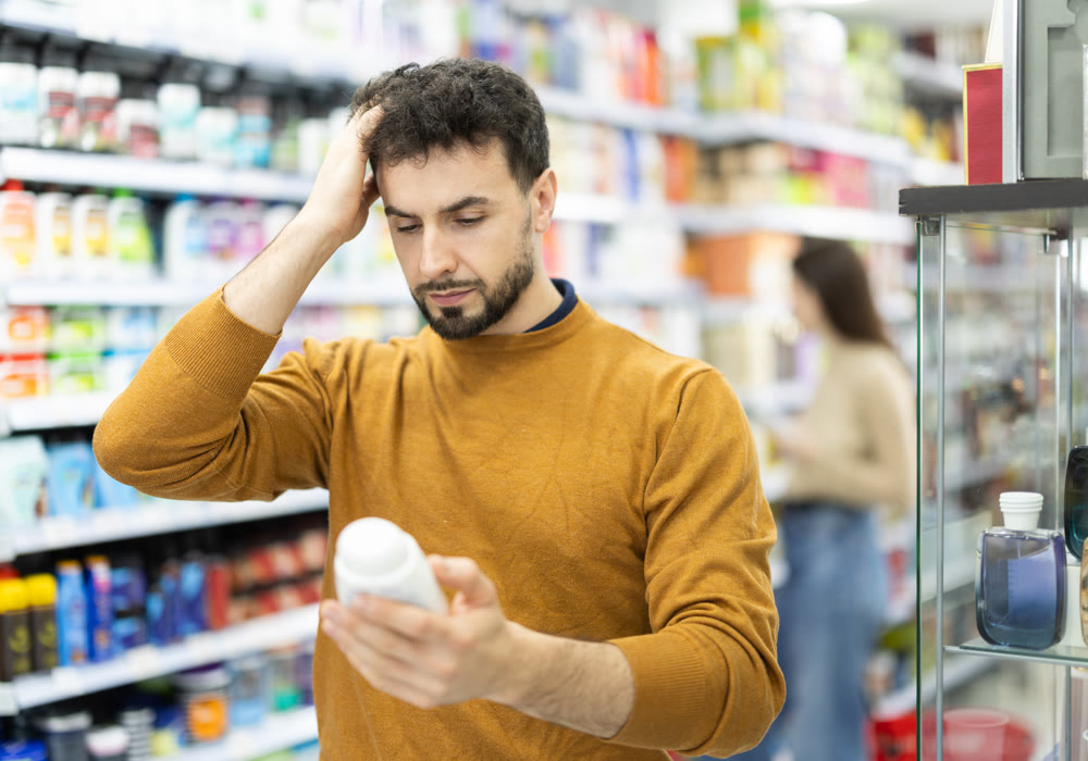 Male shopper is shopping in a supermarket, buying body care products