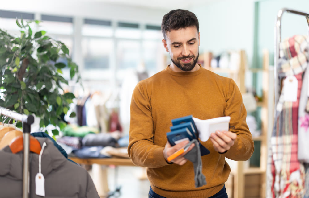 Young man chooses socks in clothing store