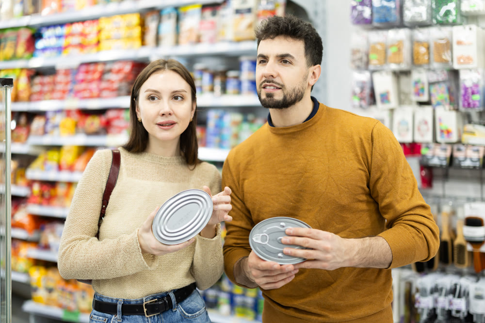 Young couple chooses canned goods in store