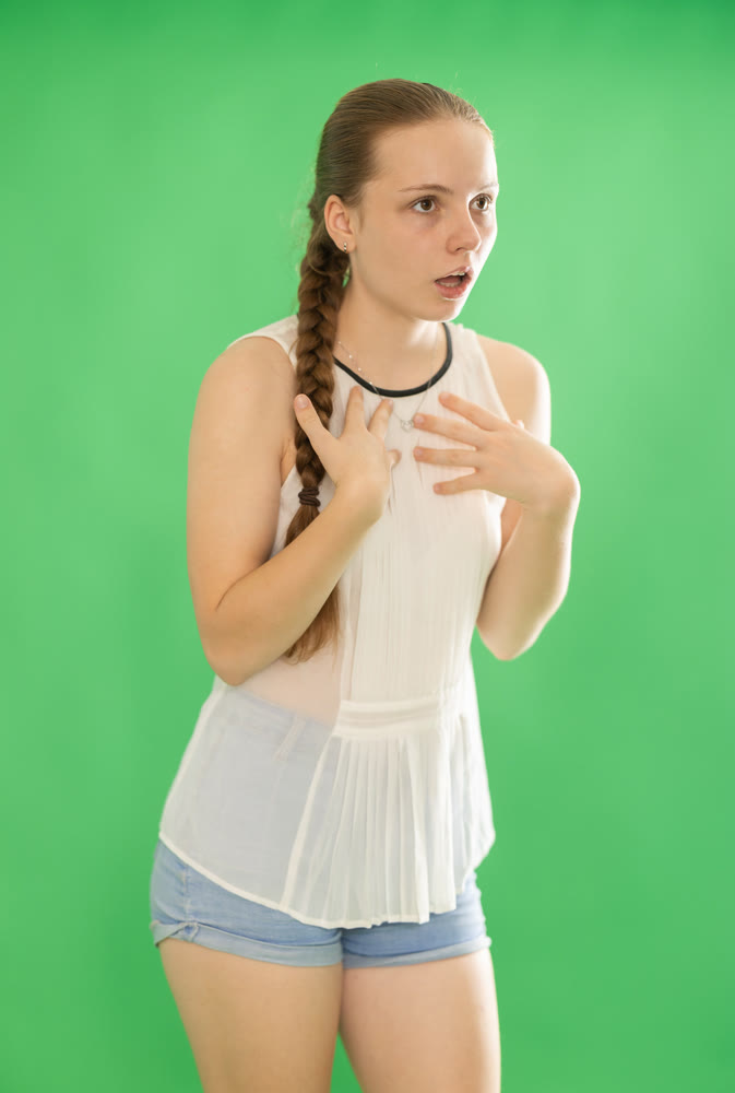 woman in blouse and shorts speaks on the background of chroma key
