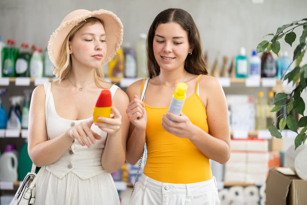 Two friends girls view trademark sign on label, pick eco friendly insect repellent