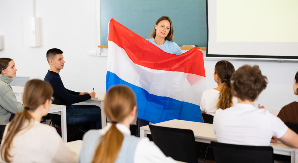 Female professor shows students flag of Netherlands