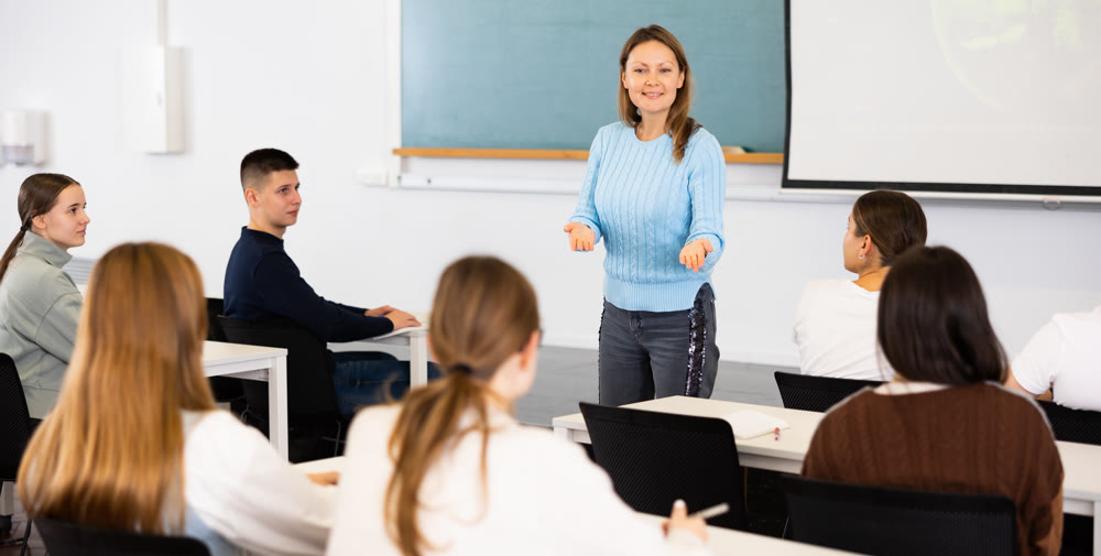 Female teacher teaching high school students in school classroom