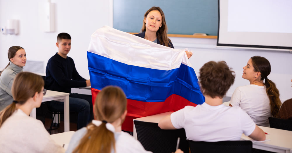 Female professor shows students Russian flag