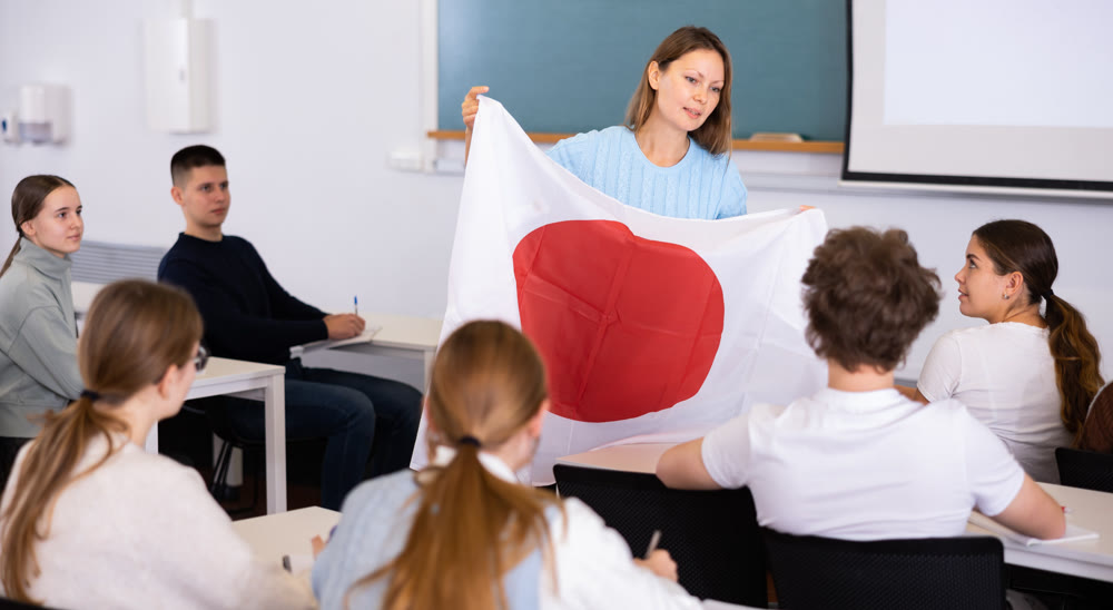 Female professor shows students flag of Japan