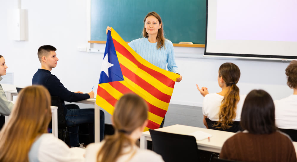 Female professor shows students estalada flag of Catalonia