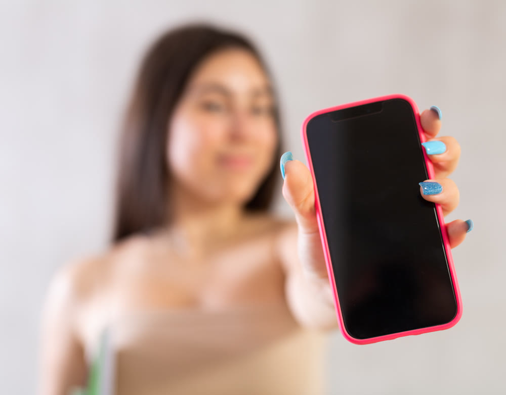 Mobile phone held in hand against blurred background