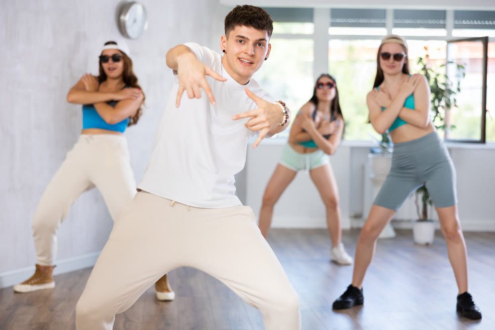 Portrait of boys and girls training hip hop movements during group class in studio