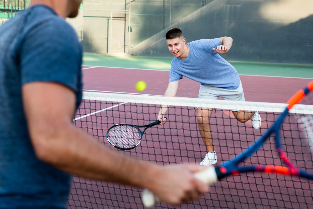 Focused young man playing friendly tennis match. Concept of concentration in competition
