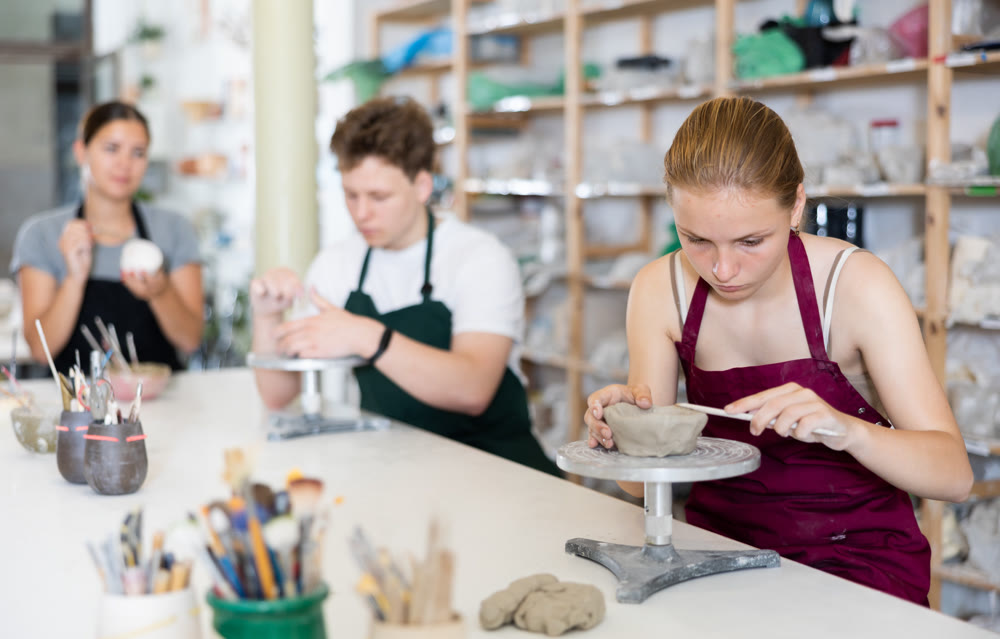 Teenage girl and teenage boy sculpt ceramic product