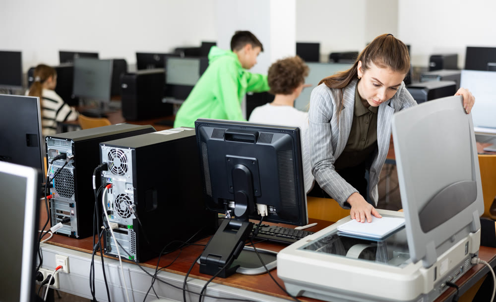 Woman copying notes on copy machine in library computer lab