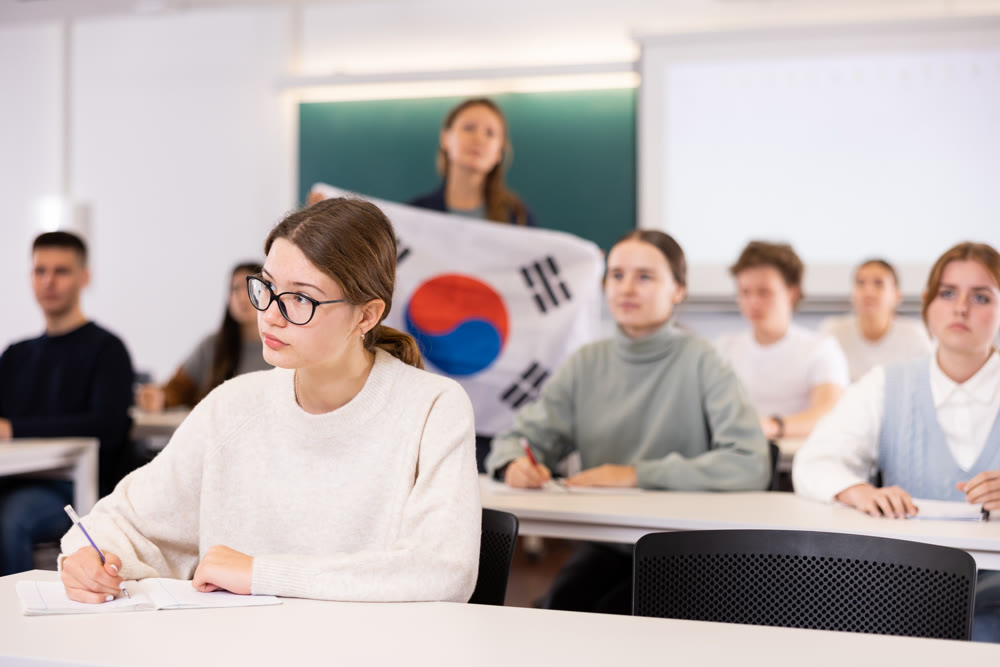 High school teacher holds the flag of South Korea in her hands and talks about this country in geography lesson