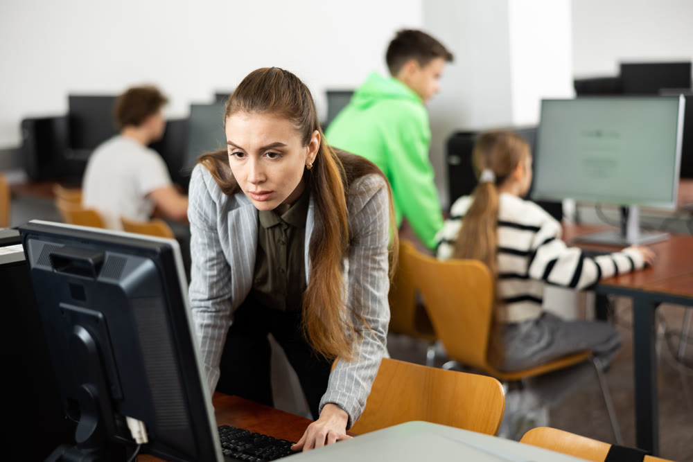 Female teacher working on computer in class