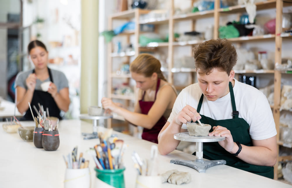 Teenage girl and teenage boy sculpt ceramic product