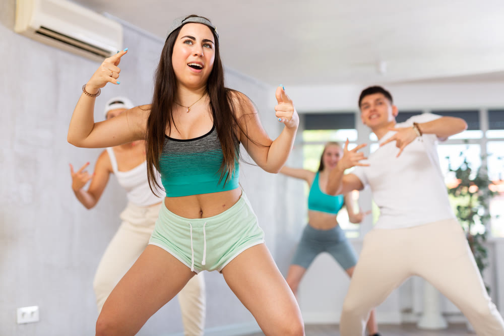 Group of young women and young guy dancing hip hop