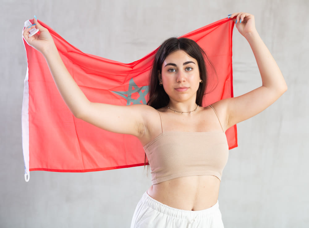 Young woman with flag of Morocco posing in studio