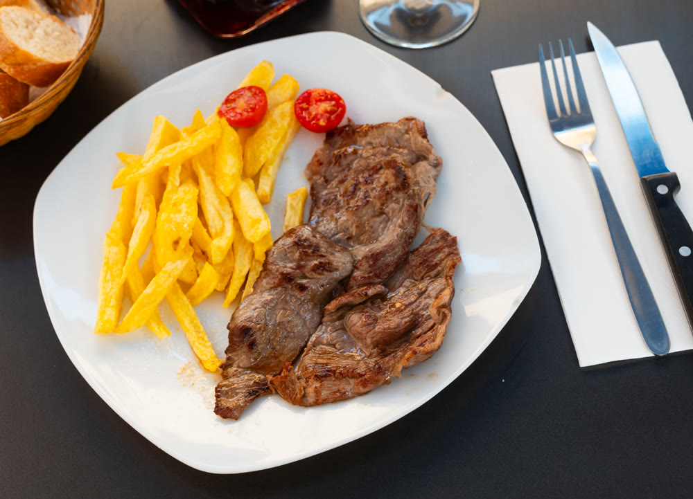 Deep-fried beef chop with French fries, served with red wine