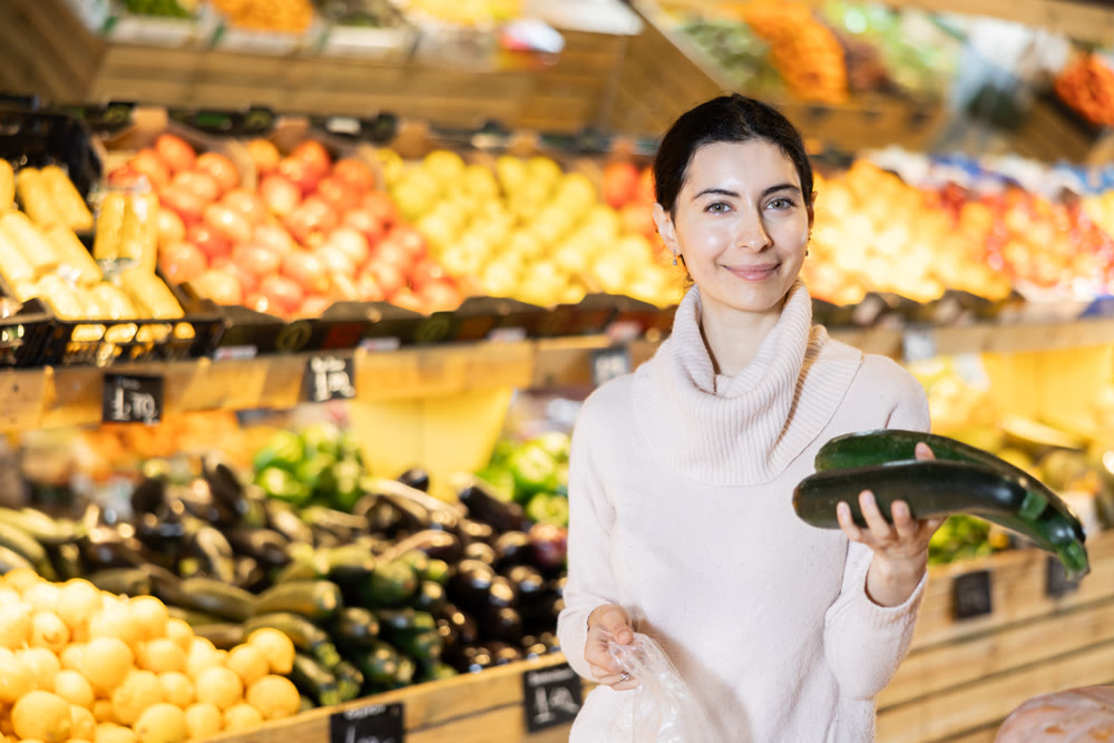 Armenian woman choosing zucchini in a vegetable store