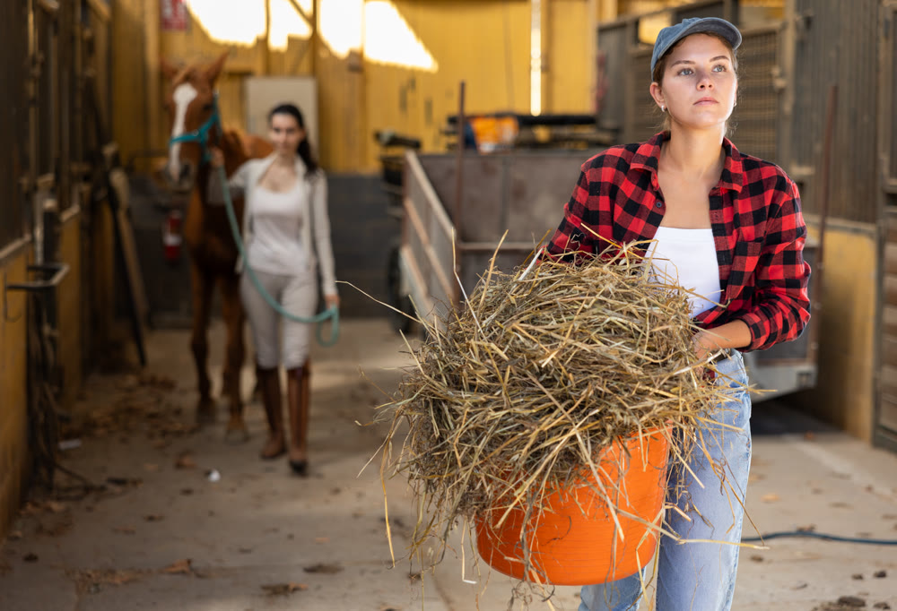 Young woman with hay in bucket