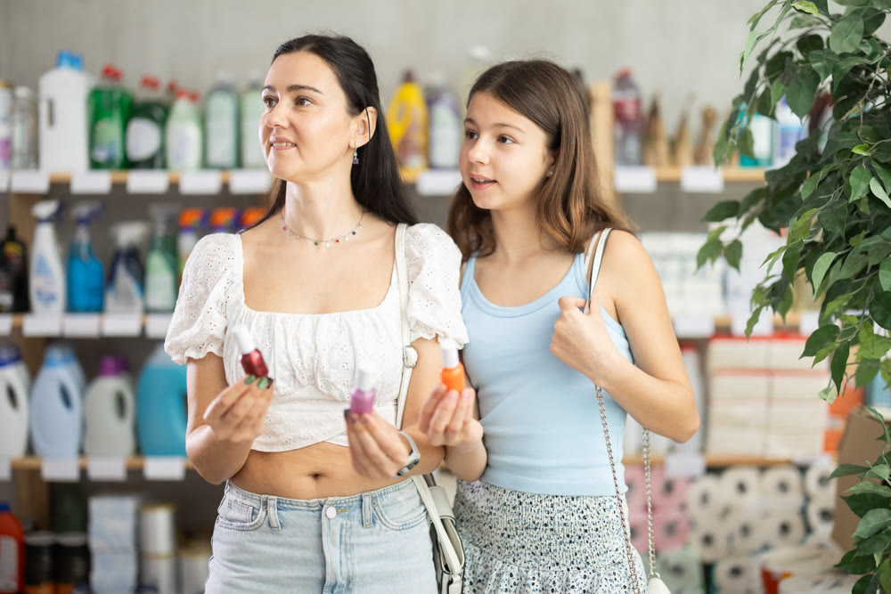 Woman with daughter choosing nail polish in store