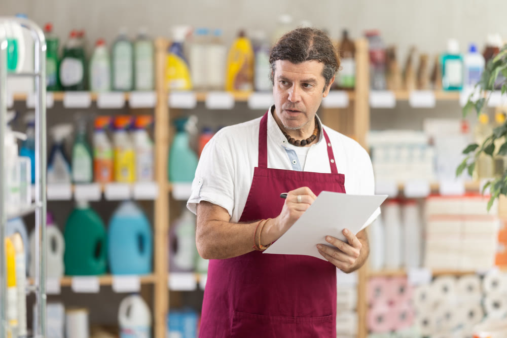 Adult man seller conducting inventory in store