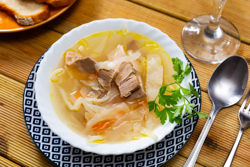 Tasty Russian dish Shchi - sour cabbage soup served in bowl