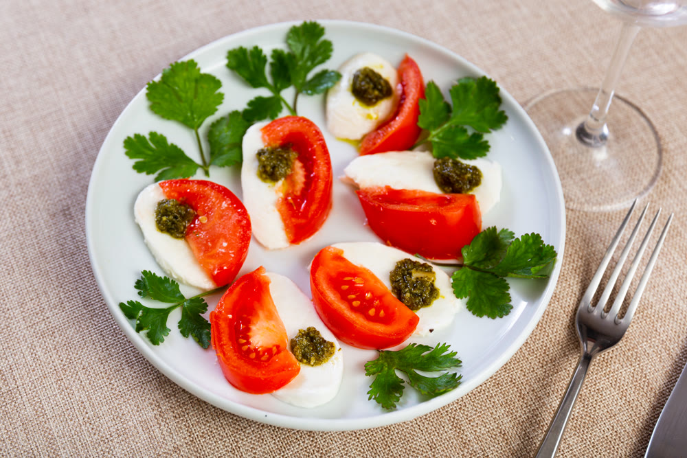 Caprese salad with pesto sauce and cilantro