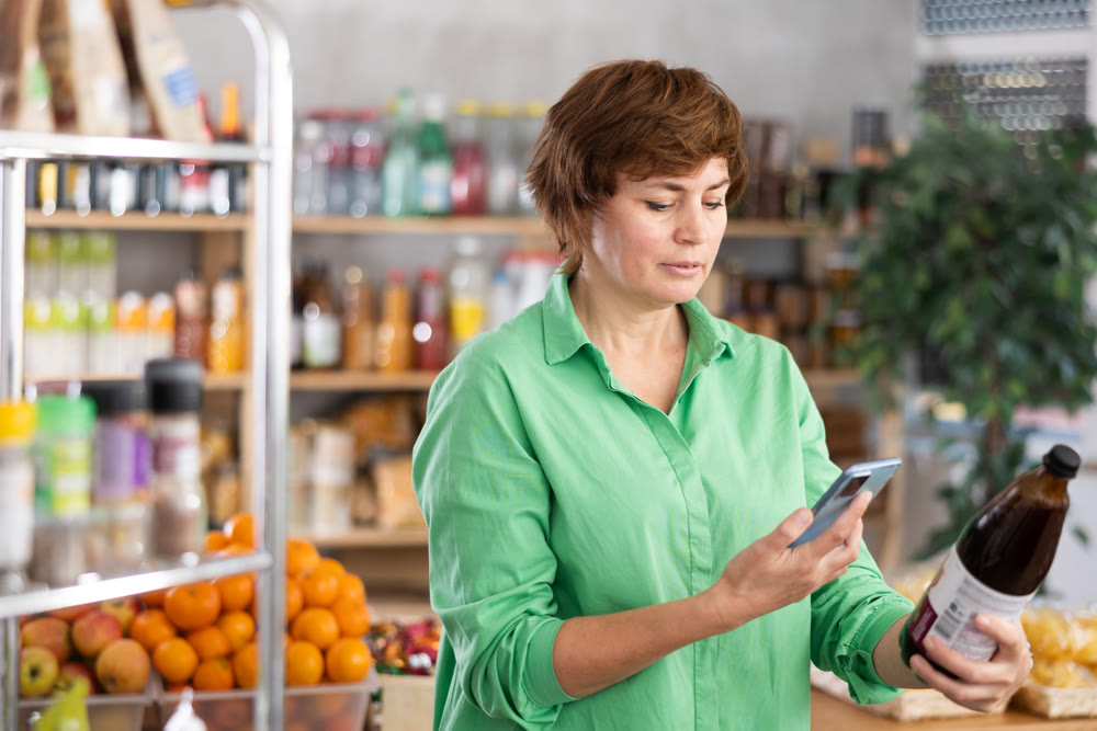 Adult woman scanning qr code of pomegranate juice