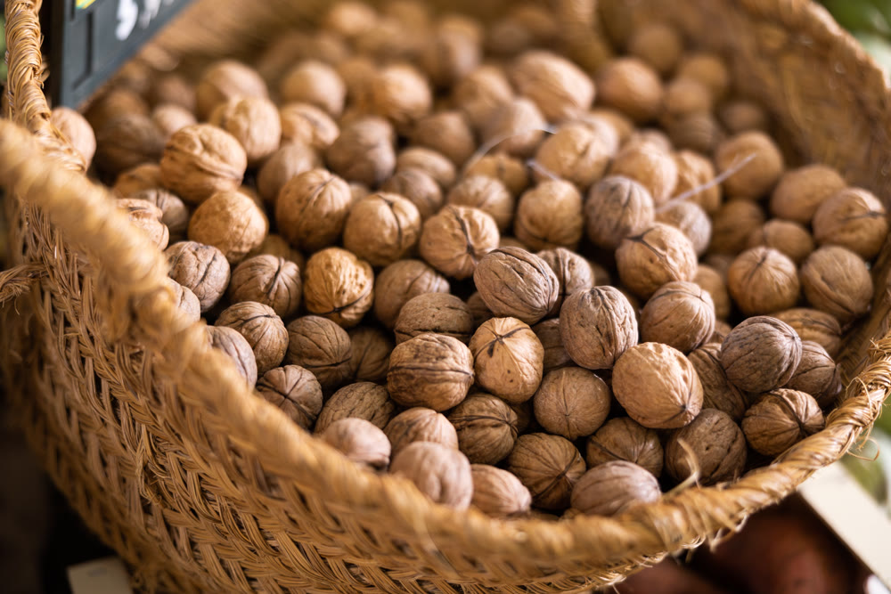 Pile of unshelled walnuts on store counter