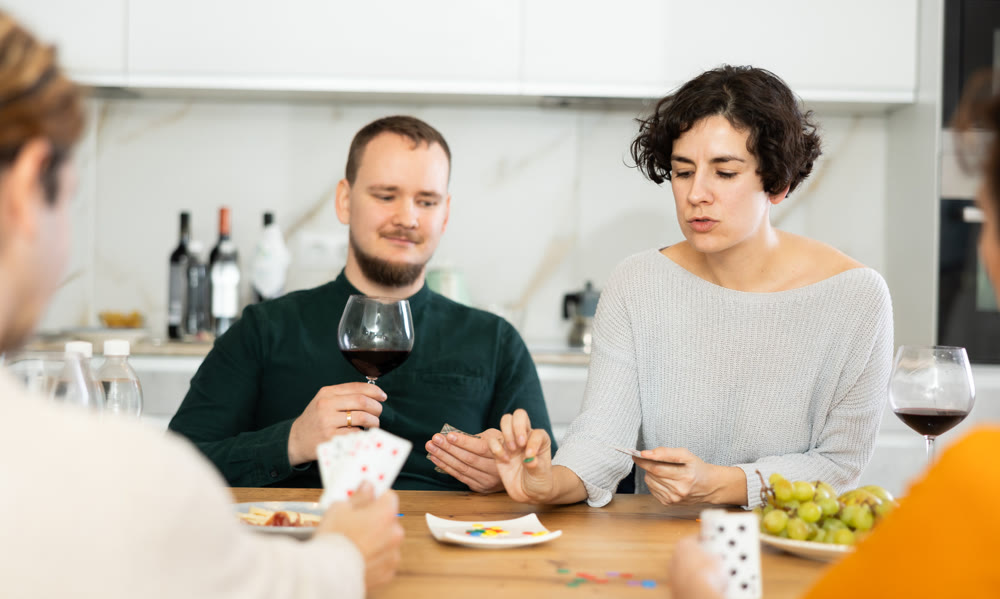 Two married couples playing card game poker