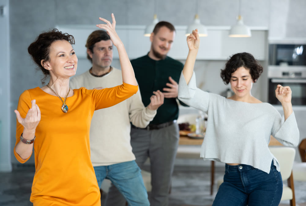 Men and women doing couple dancing during house party.