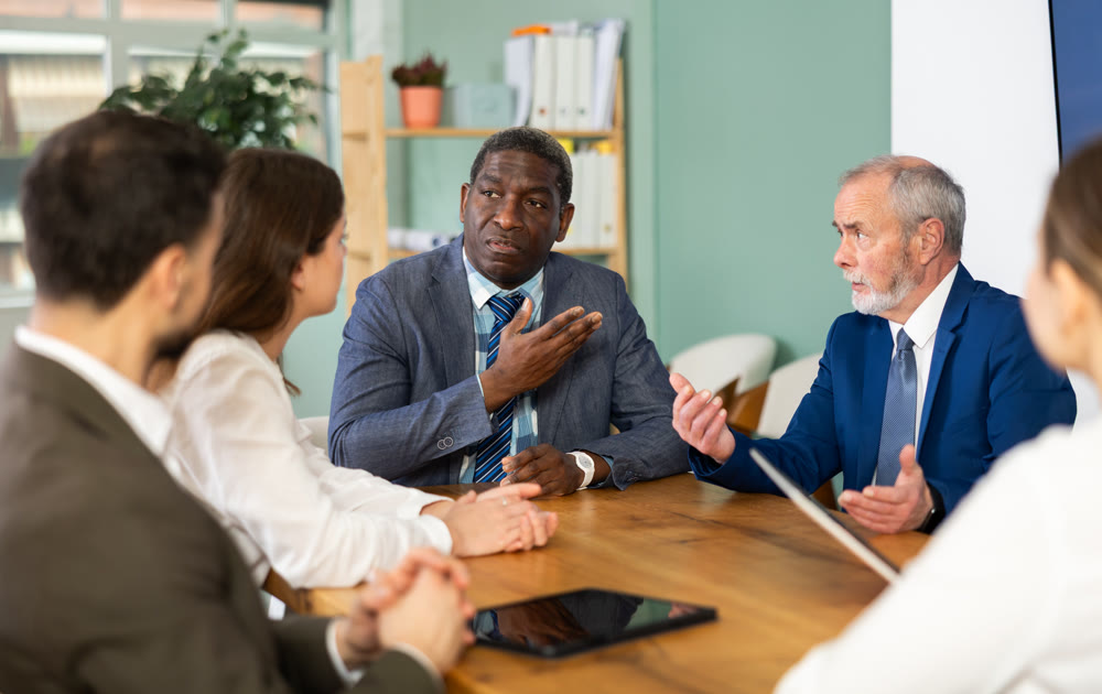Group of businessmen and businesswomen holding meeting at table