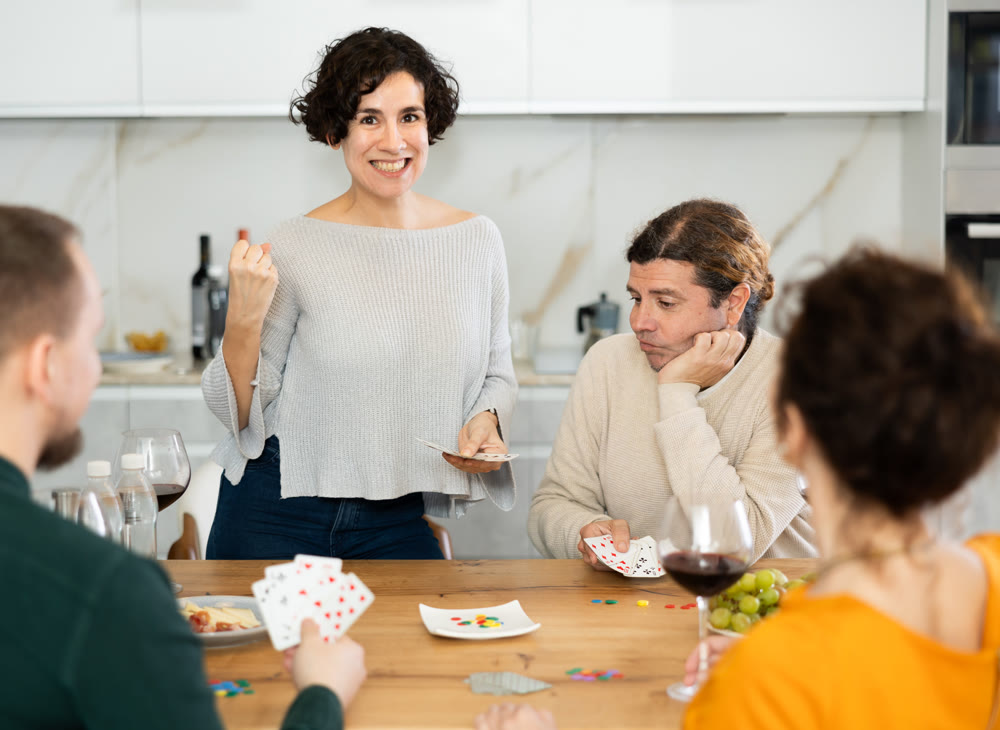 Two married couples playing card game poker