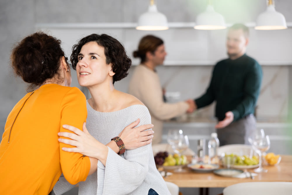 After chatting and gatherings, women friends hug and kiss goodbye.