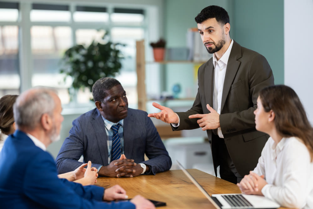 Young man leading meeting at office table