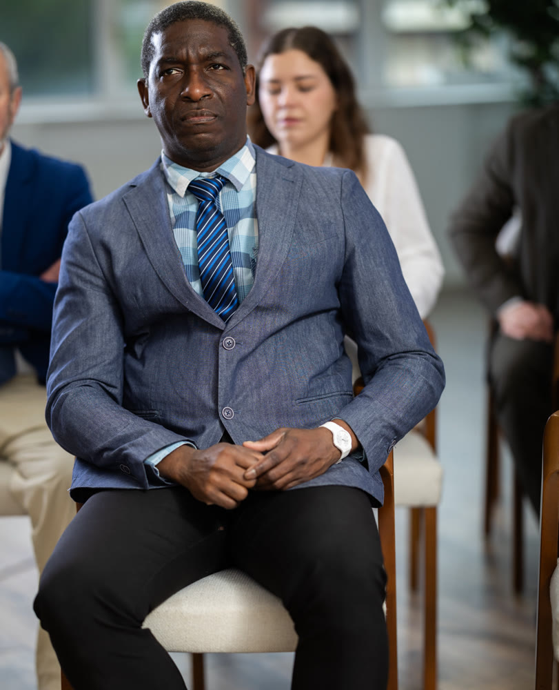 African male businessman courses visitor at meeting listens to teacher and look at speaker