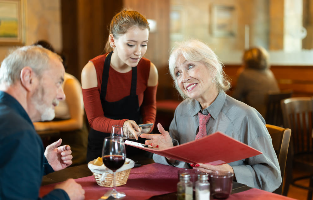 Waitress takes order from couple elderly man and woman