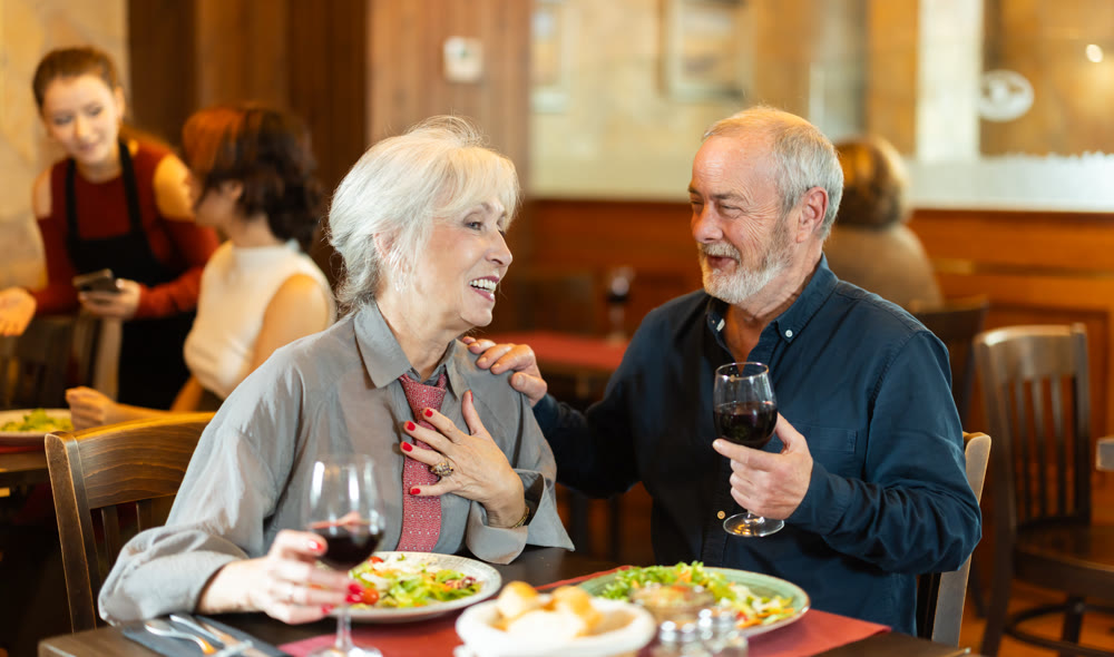 Happy senior couple enjoying dinner together in restaurant