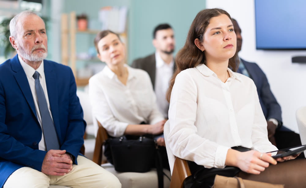 Young woman listens to presentation in conference room